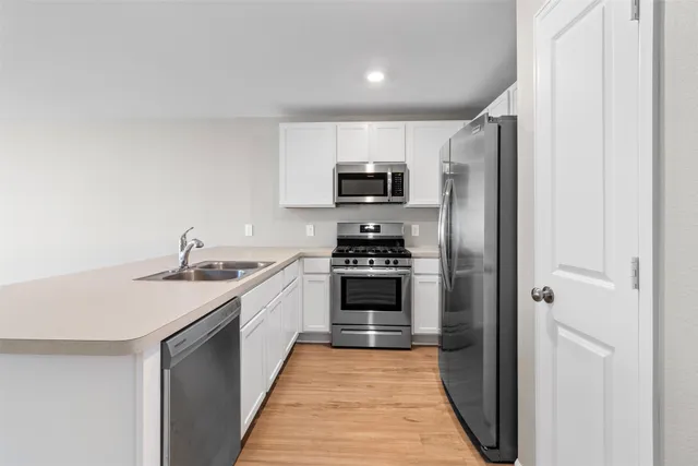 a kitchen with stainless steel appliances a refrigerator stove and sink