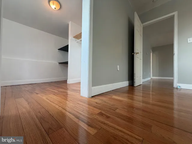 an empty room with wooden floor and closet