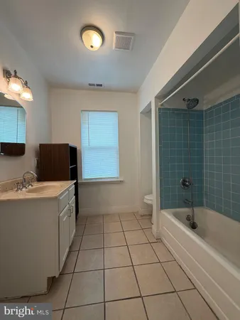 a bathroom with a tub sink and mirror