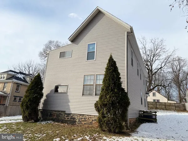 a view of a white house next to a yard