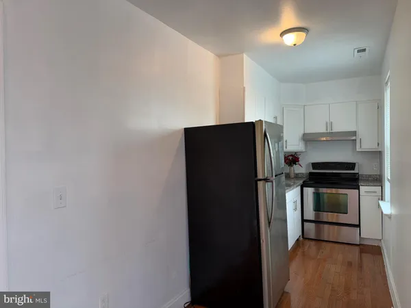 a kitchen with granite countertop a stove sink and cabinets