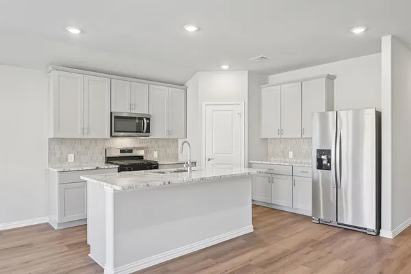 a kitchen with stainless steel appliances a refrigerator sink and microwave