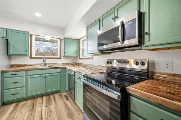 a kitchen with stainless steel appliances granite countertop a sink and a stove