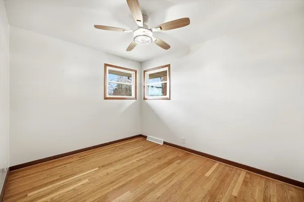 an empty room with a window and a fan