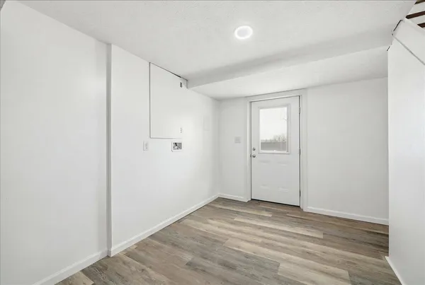 a view of an empty room with wooden floor