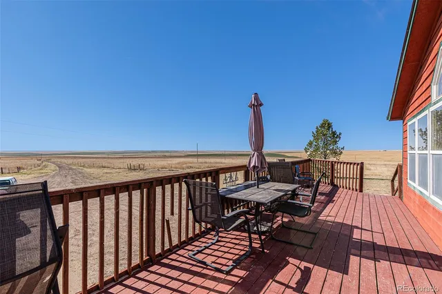 a view of a balcony with wooden floor and outdoor seating