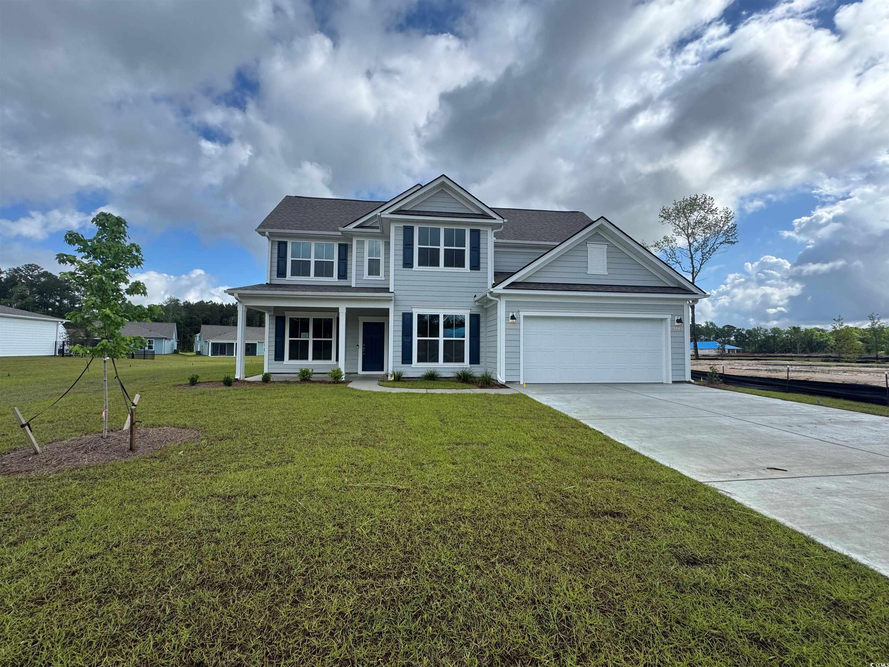 View of front facade with driveway, a front lawn,