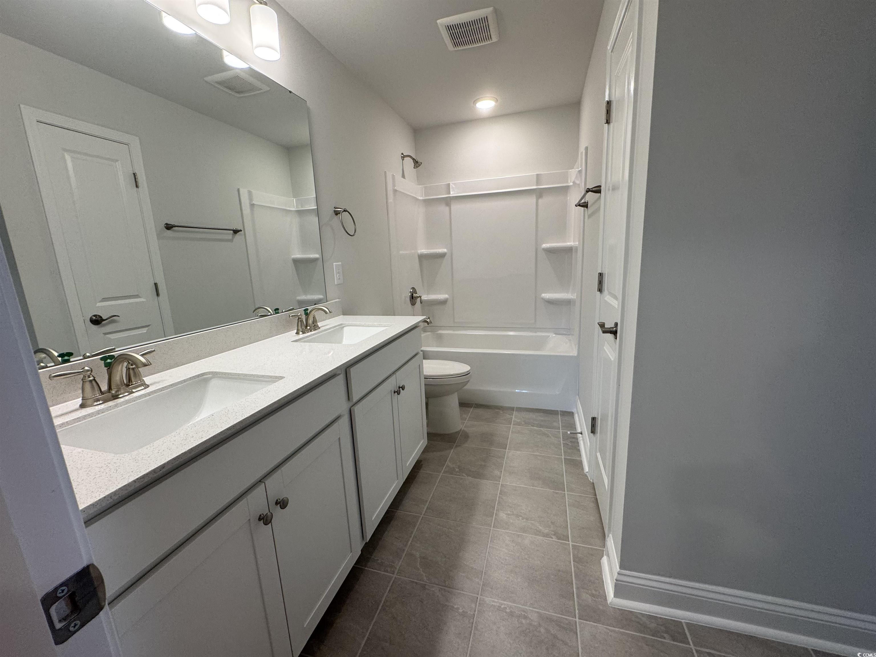 9409 Long Meadow Way Longs, SC 29568 - Photo 17 of 17 Full bathroom with double vanity, tile patterned f