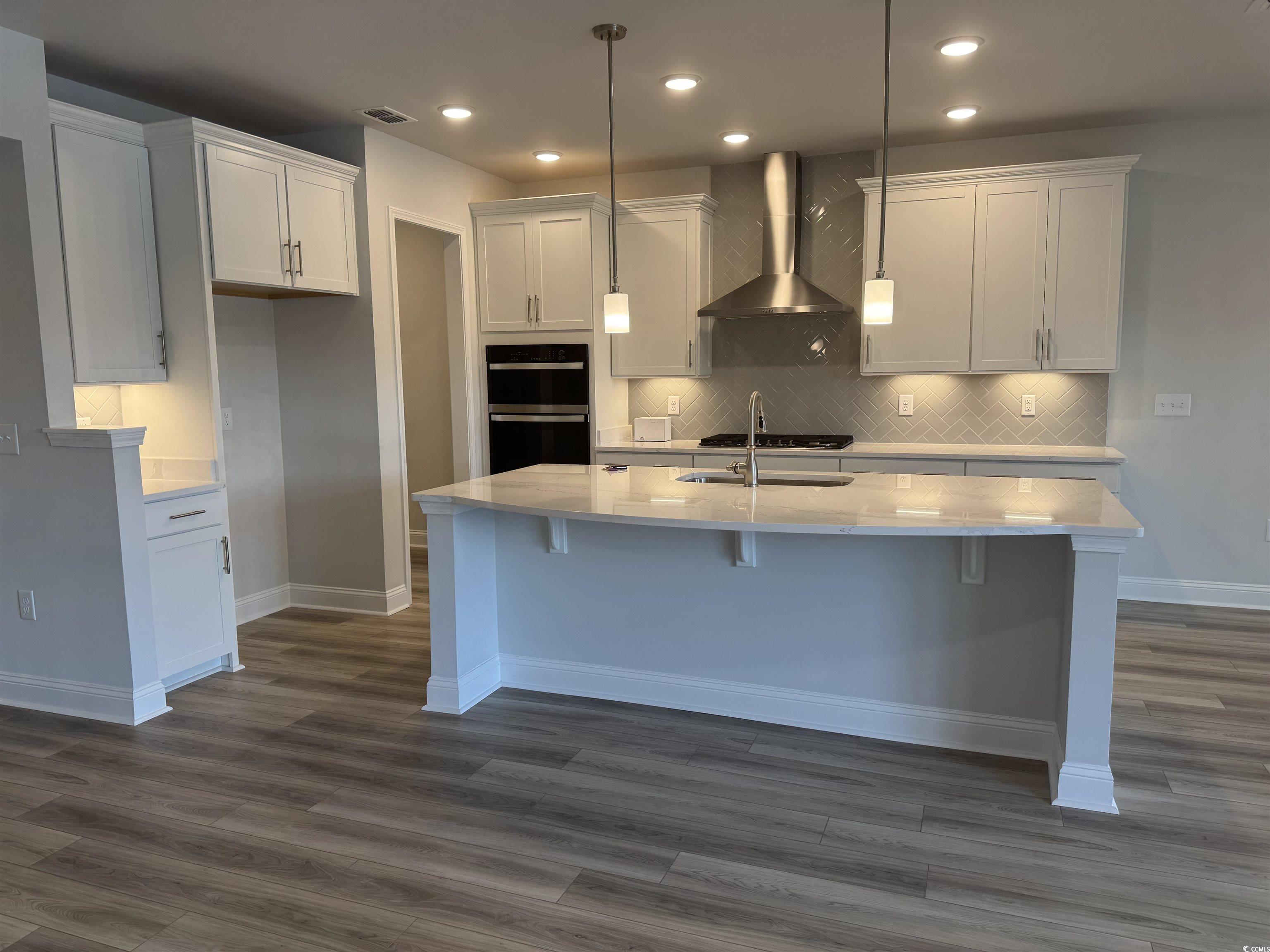 9409 Long Meadow Way Longs, SC 29568 - Photo 3 of 17 Kitchen featuring wall chimney range hood, a sink,