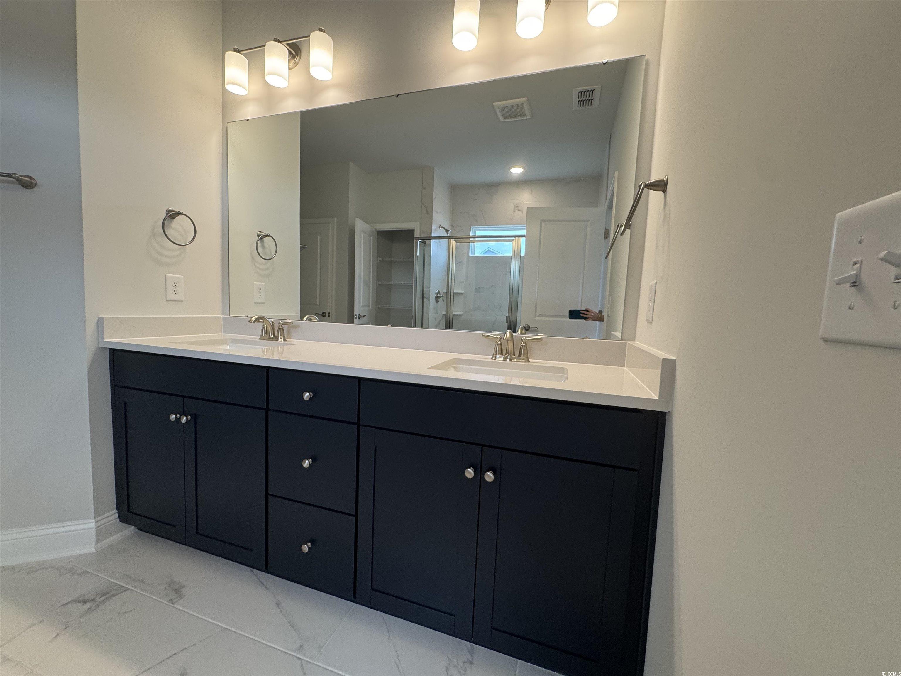 9409 Long Meadow Way Longs, SC 29568 - Photo 6 of 17 Bathroom with double vanity, a stall shower, marbl