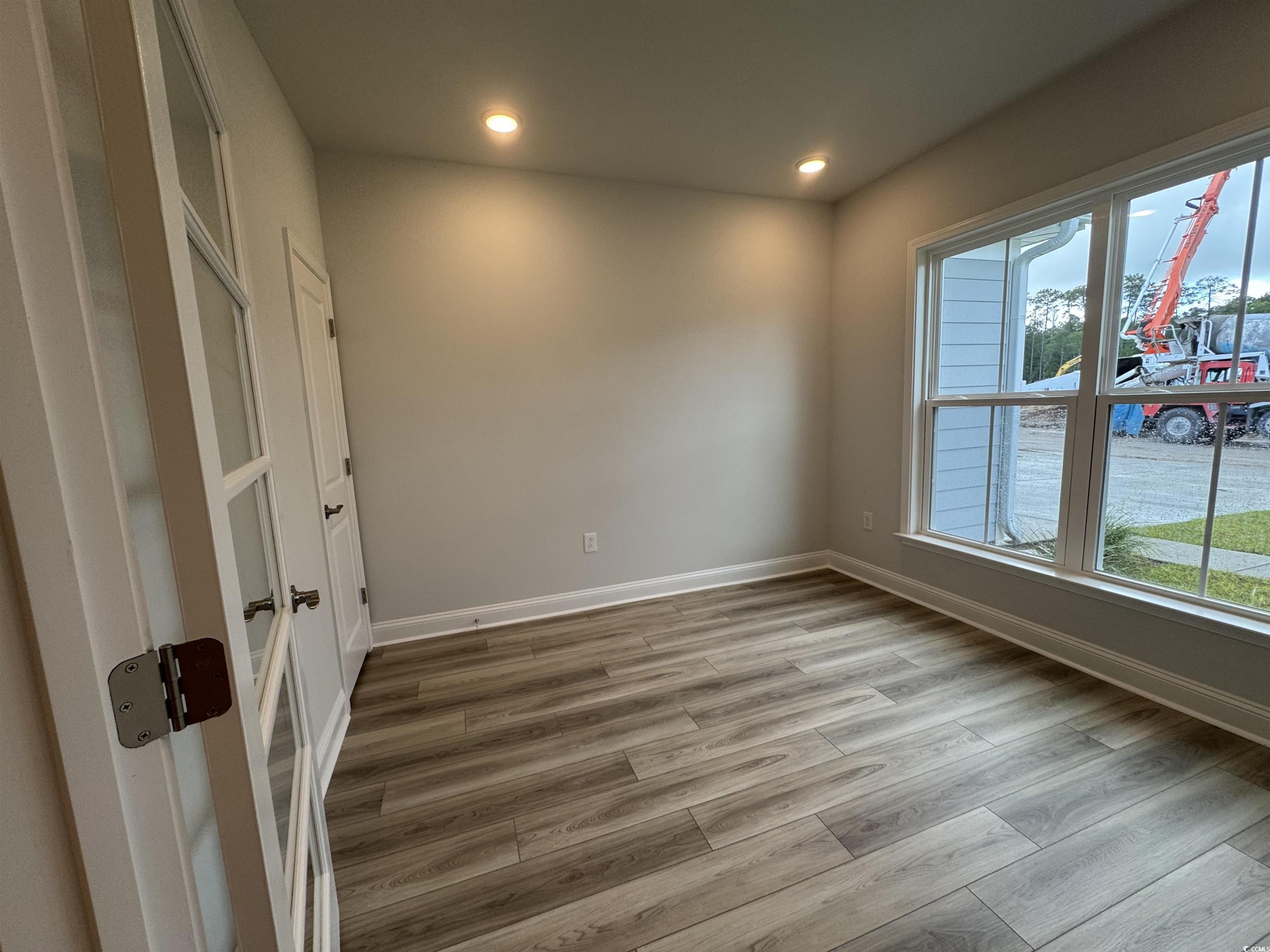 9409 Long Meadow Way Longs, SC 29568 - Photo 8 of 17 Empty room with wood finished floors, recessed lig