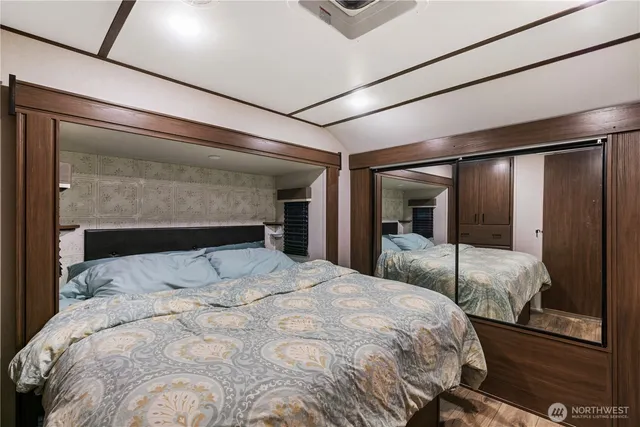a large bed sitting in a bedroom next to a window