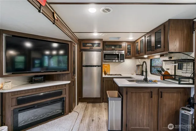 a kitchen with stainless steel appliances kitchen island granite countertop a refrigerator and a stove top oven