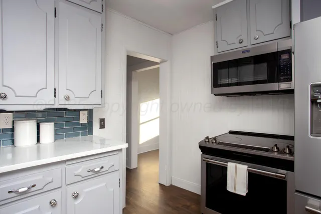 a kitchen with stainless steel appliances a sink a stove and cabinets