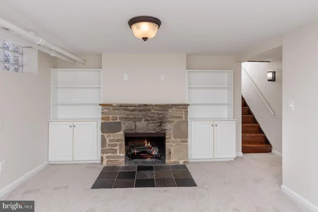 an empty room with windows and fireplace