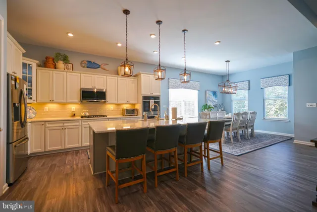 a kitchen with stainless steel appliances granite countertop a sink a stove and a refrigerator