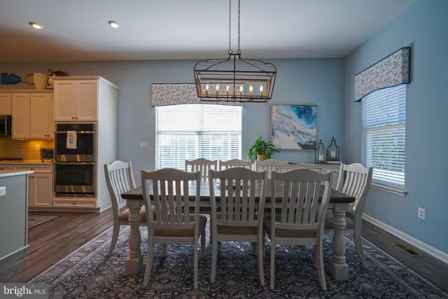 a bedroom with a bed a chandelier and a dresser