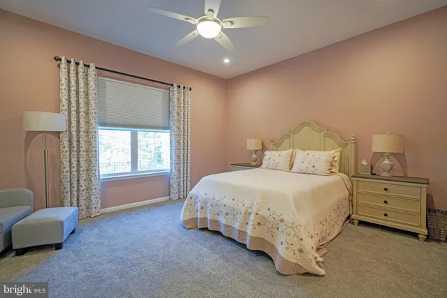 a bed sitting in a bedroom next to a window and a lamp