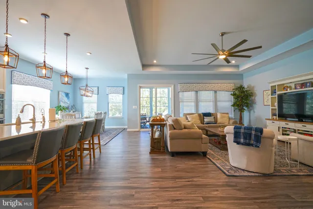 a living room with furniture kitchen view and a large window