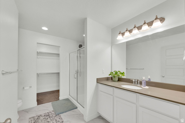 6120 North Sheps Ridge Road Eagle Mountain, UT 84005 - Photo 11 of 43 Bathroom featuring a single vanity with an integrated sink, broad mirror, and a five-light fixture