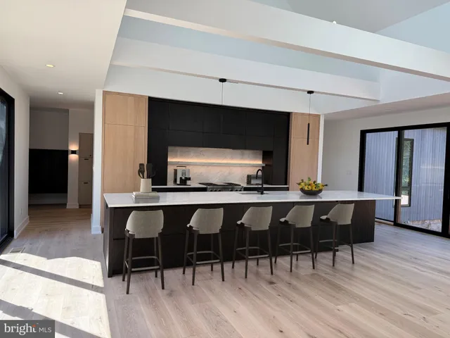 a living room with stainless steel appliances kitchen island granite countertop wooden floors and wooden cabinets