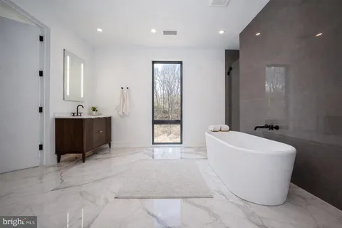 a bathroom with a bathtub sink and mirror