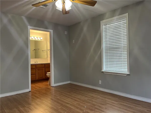 an empty room with wooden floor chandelier fan and closet area