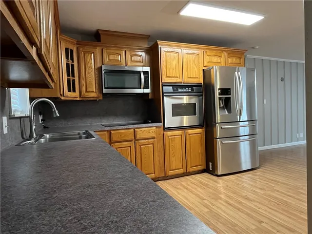 a kitchen with stainless steel appliances granite countertop a refrigerator and a sink