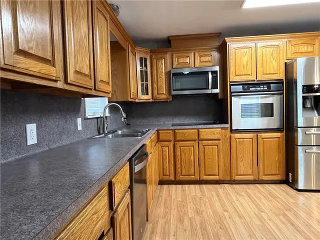 a kitchen with stainless steel appliances granite countertop a sink a stove and cabinets