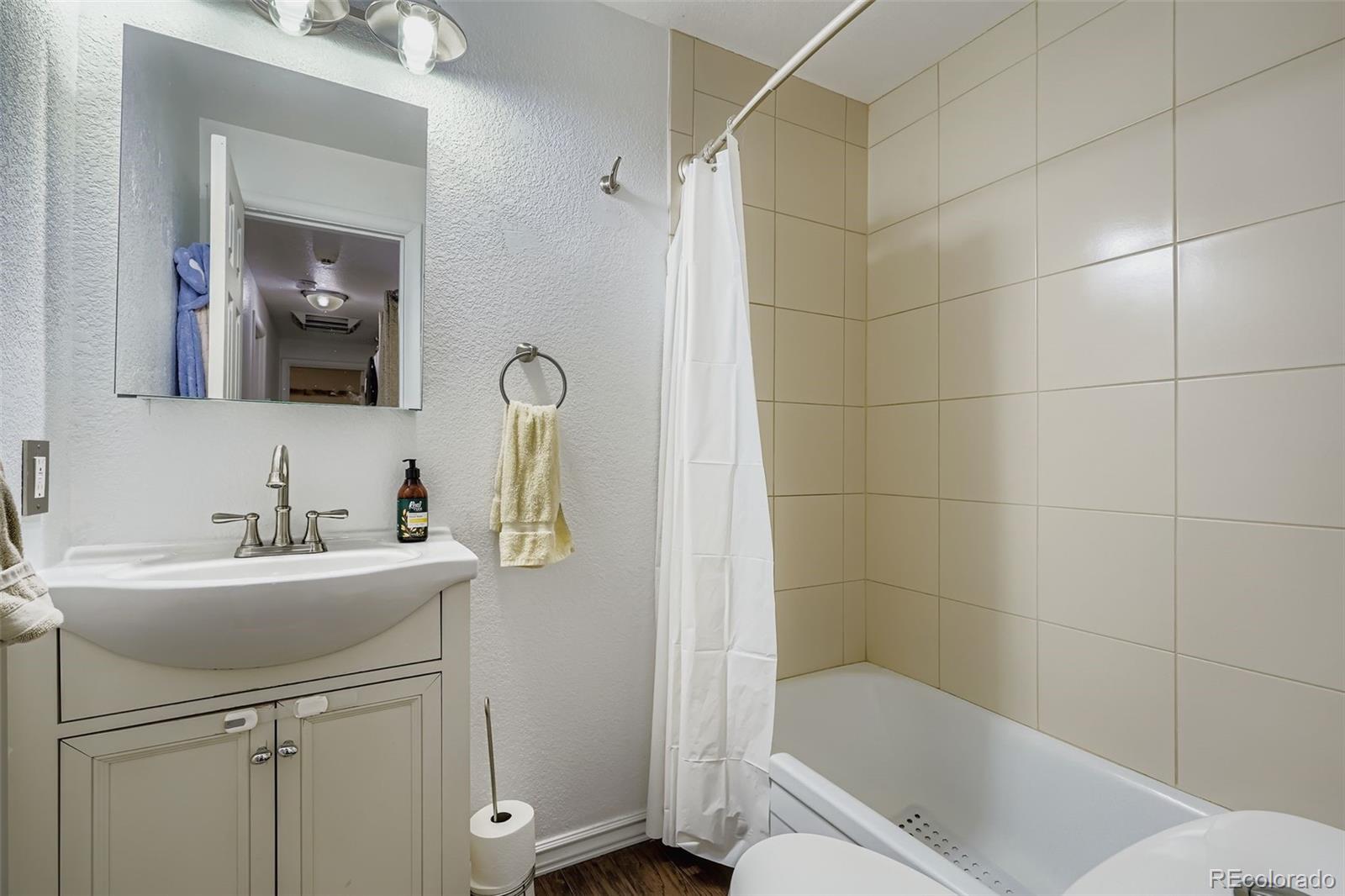 4720 Carr Street Wheat Ridge, CO 80033 - Photo 14 of 31 a bathroom with a sink a toilet and tub