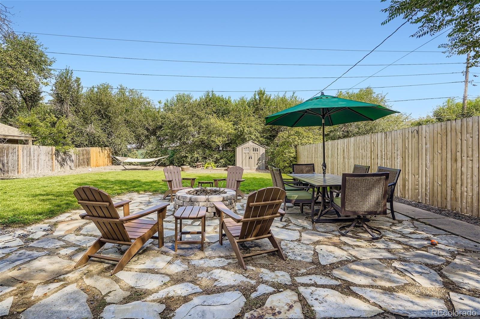 4720 Carr Street Wheat Ridge, CO 80033 - Photo 18 of 31 a view of a patio with table and chairs under an umbrella