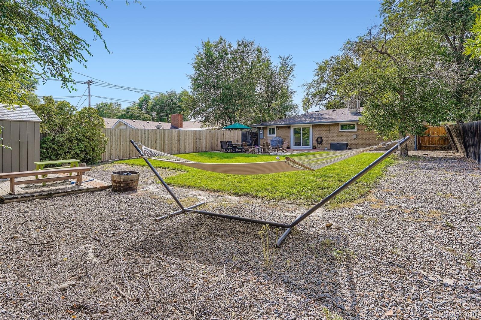 4720 Carr Street Wheat Ridge, CO 80033 - Photo 19 of 31 a view of a house with a yard and trees in the background