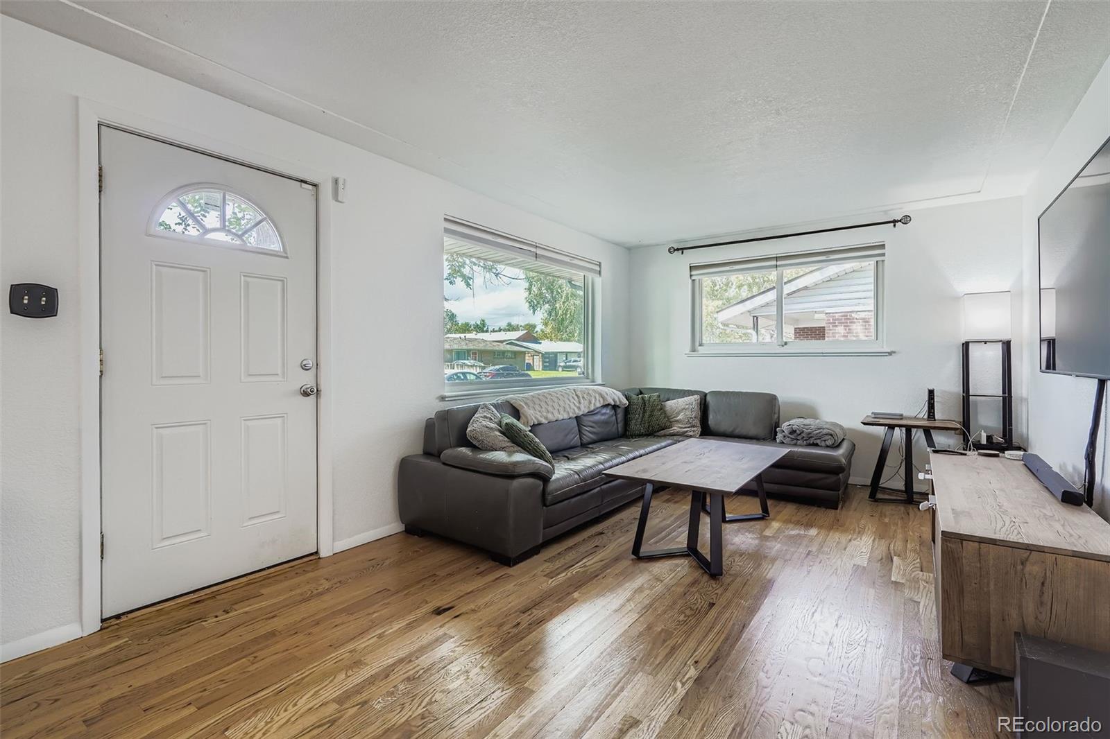 4720 Carr Street Wheat Ridge, CO 80033 - Photo 2 of 31 a living room with furniture and a wooden floor