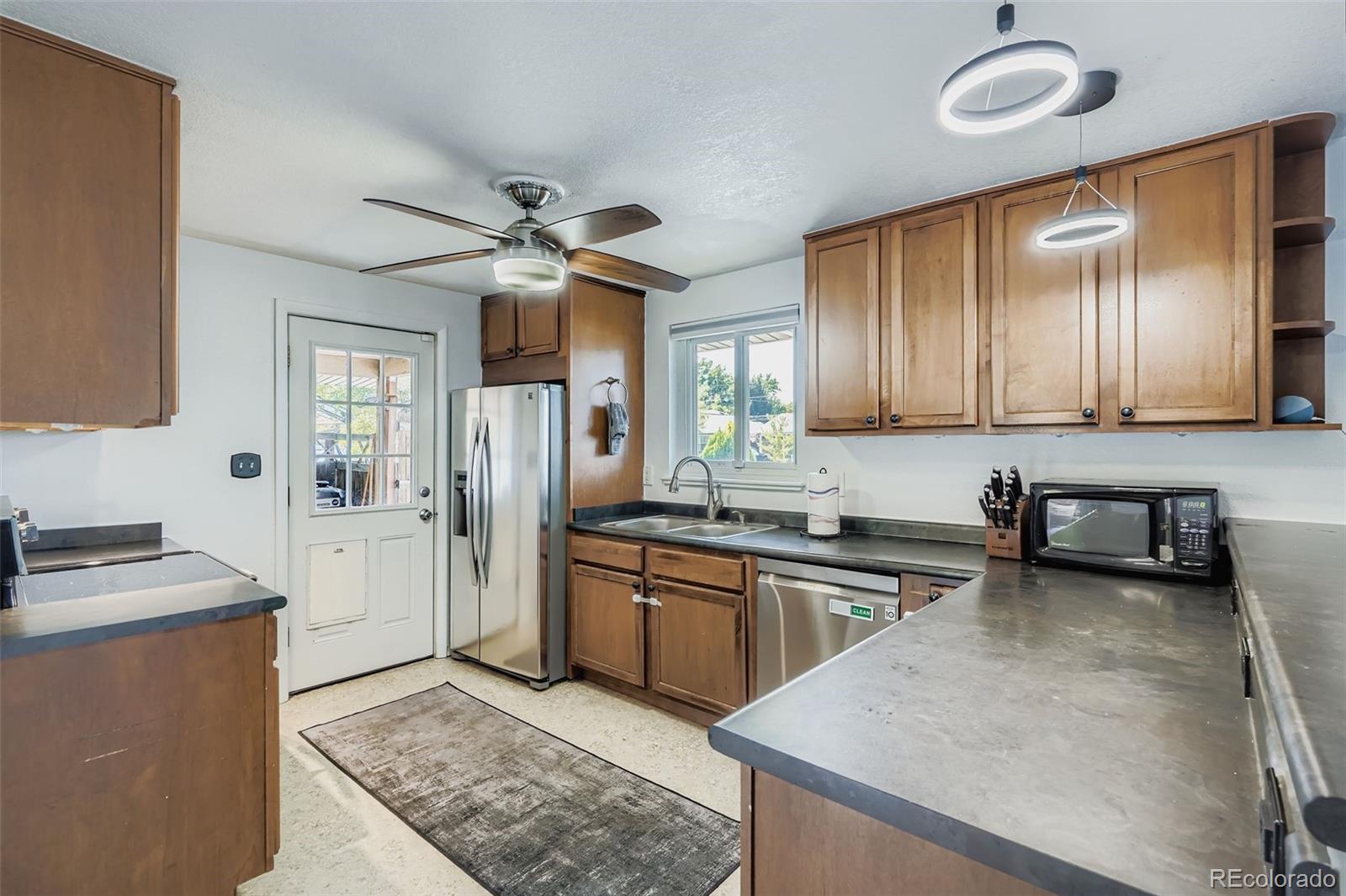 4720 Carr Street Wheat Ridge, CO 80033 - Photo 4 of 31 a kitchen with stainless steel appliances granite countertop a sink stove and refrigerator