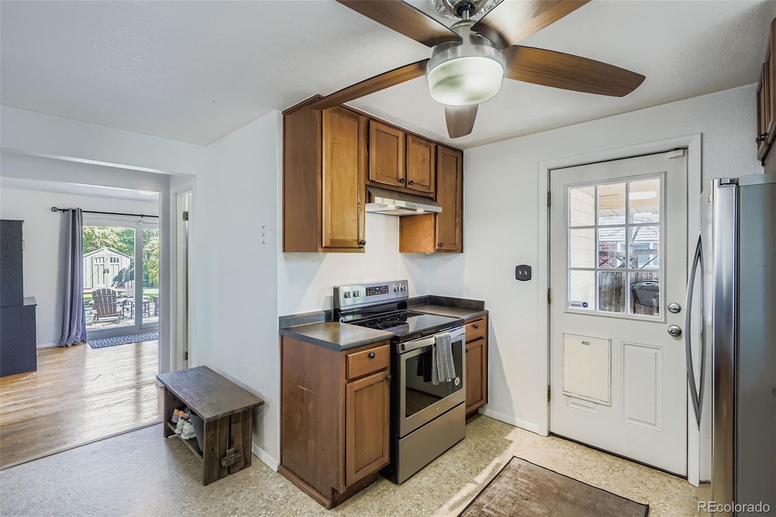 4720 Carr Street Wheat Ridge, CO 80033 - Photo 5 of 31 a kitchen with stainless steel appliances granite countertop a stove and a sink