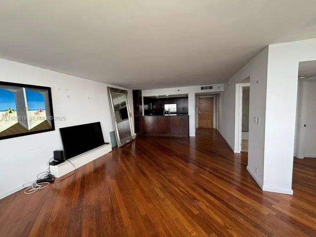 a view of empty room with wooden floor and fireplace
