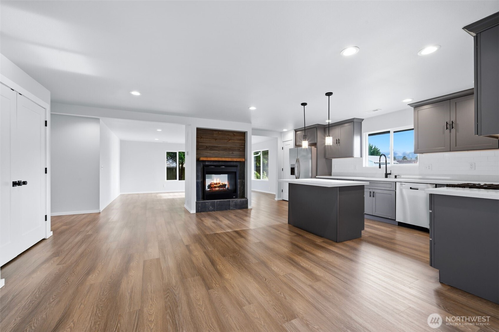 731 High Avenue Sultan, WA 98294 - Photo 8 of 37 a open kitchen with kitchen island a sink dishwasher a stove and a refrigerator with wooden floor