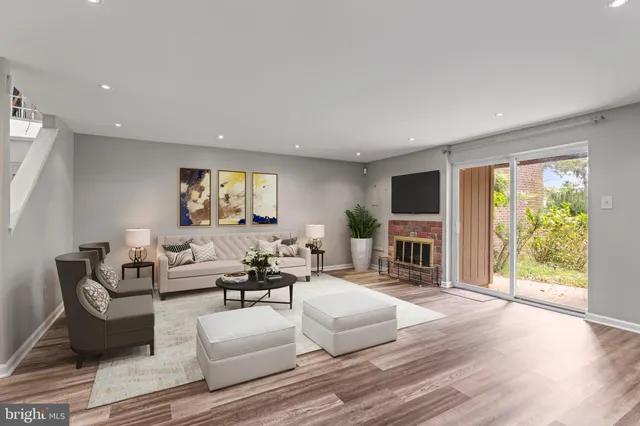 an empty room with wooden floor fireplace and windows