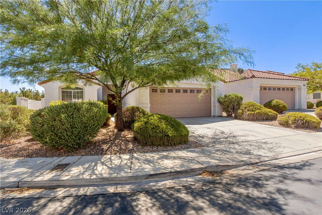 1815 Stablegate Avenue Henderson, NV 89012 - Photo 24 of 28 A terracotta-tiled roof crowns this residence, featuring desert-friendly landscaping and a paved driveway.