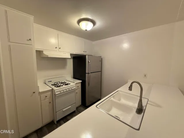 a kitchen with a stove top oven and sink