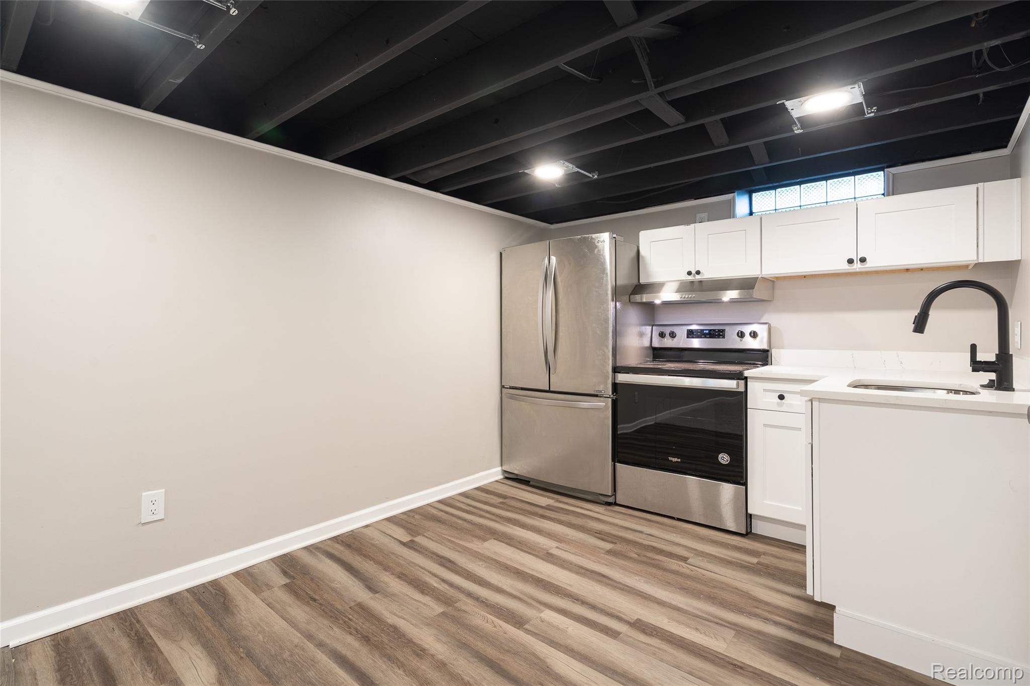 201 Cardwell Street Inkster, MI 48141 - Photo 28 of 41 Kitchenette featuring stainless steel appliances, white cabinetry, a black matte faucet, light countertops, and wood-finish flooring