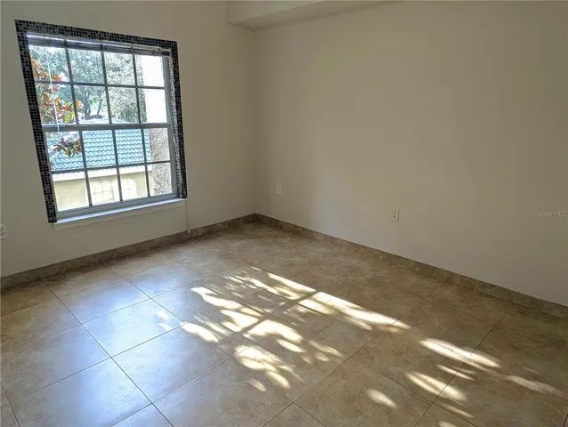 a view of an empty room with closet and a window
