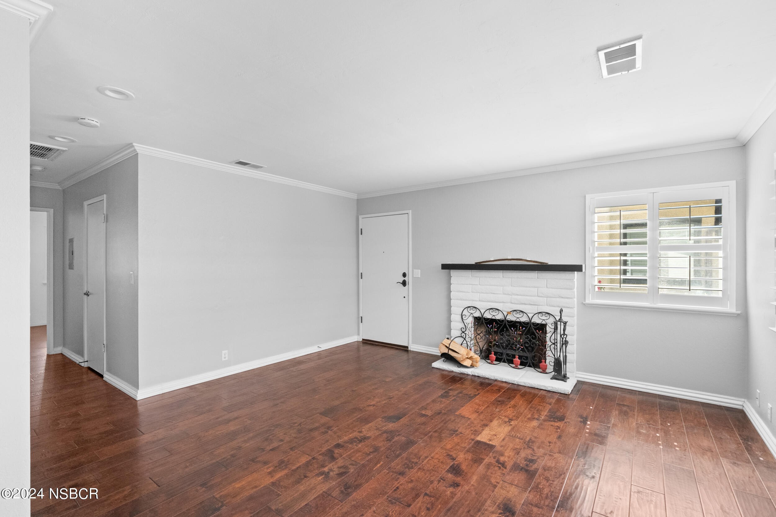 1113 James Way Arroyo Grande, CA 93420 - Photo 5 of 30 an empty room with wooden floor fireplace and window