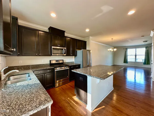 a kitchen with stainless steel appliances granite countertop a sink stove and refrigerator