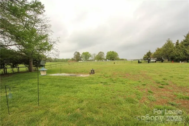 a yard with lots of green space and trees