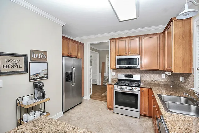 a kitchen with granite countertop a refrigerator and a sink