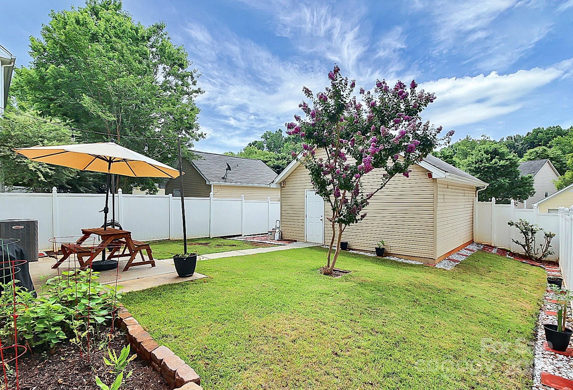 10008 Caldwell Depot Road Cornelius, NC 28031 - Photo 23 of 33 a view of a backyard with a table and chairs under an umbrella