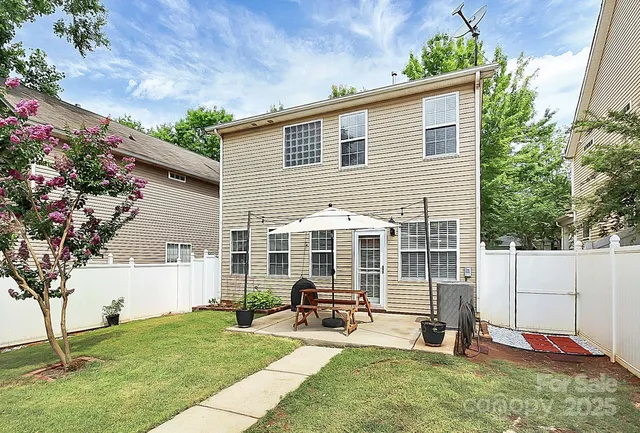 a view of a house with backyard and a tree