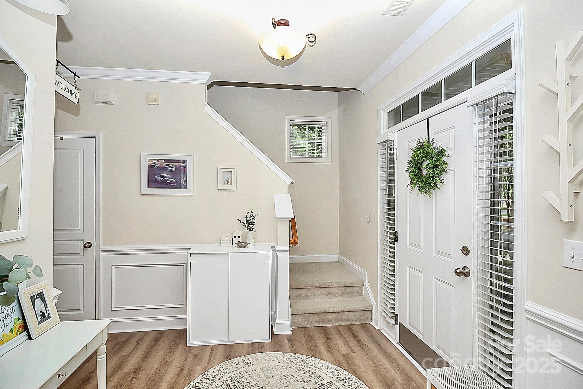 10008 Caldwell Depot Road Cornelius, NC 28031 - Photo 4 of 33 a view of a hallway to a livingroom with furniture and wooden floor