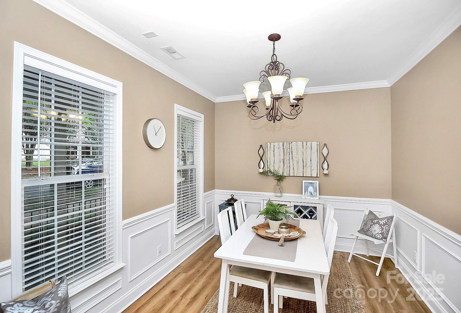 10008 Caldwell Depot Road Cornelius, NC 28031 - Photo 5 of 33 a dining room with wooden floor a chandelier a wooden table and chairs